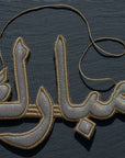 "مبارك" Mubarak Arabic Calligraphy Silver Embroidery Ornament On dark Background